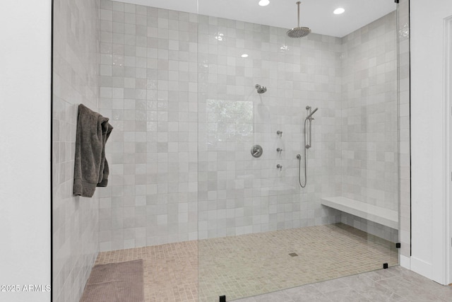 bathroom with a tile shower and tile patterned flooring