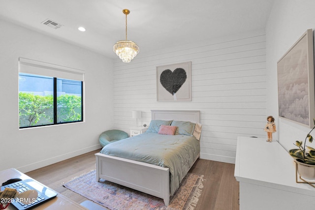 bedroom with dark hardwood / wood-style floors and a chandelier