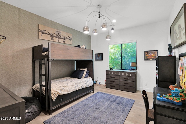 bedroom with an inviting chandelier and light wood-type flooring