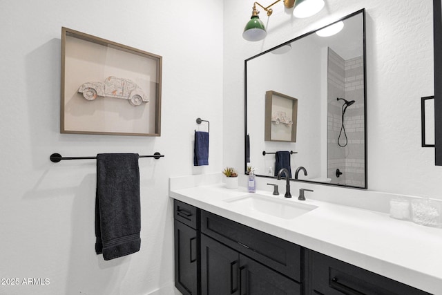 bathroom with vanity and a tile shower