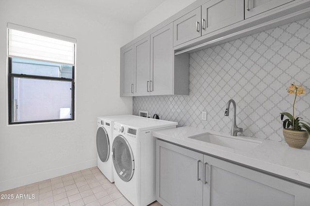 laundry room featuring cabinets, sink, light tile patterned floors, and washer and clothes dryer