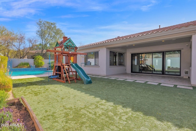 view of playground featuring a fenced in pool, a lawn, and a patio area