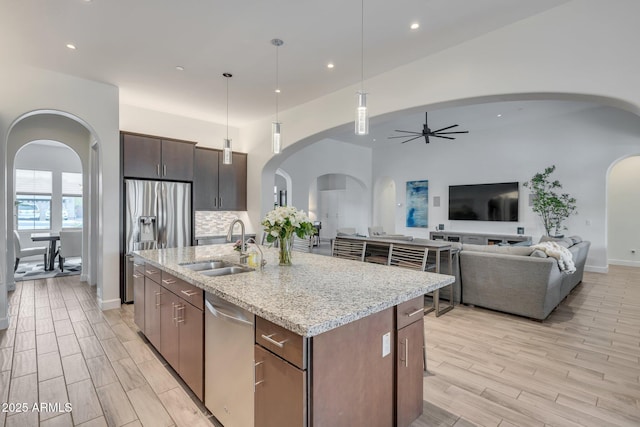10886 N 137th St, Scottsdale, AZ 85259 - kitchen with wood finish floors, ceiling fan, appliances with stainless steel finishes, arched walkways, and a sink