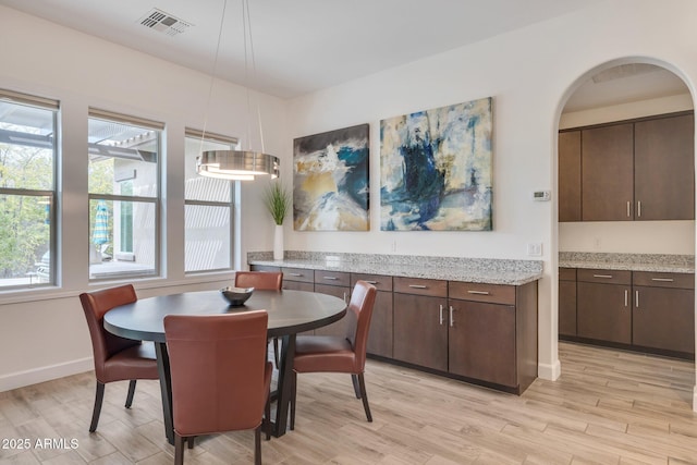 10886 N 137th St, Scottsdale, AZ 85259 - dining space featuring visible vents, baseboards, light wood-type flooring, and arched walkways