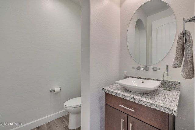 10886 N 137th St, Scottsdale, AZ 85259 - half bath with toilet, vanity, baseboards, and wood finished floors