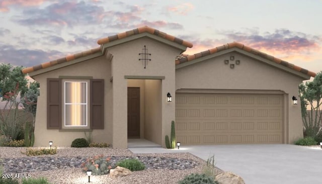 mediterranean / spanish home featuring a garage, driveway, and stucco siding