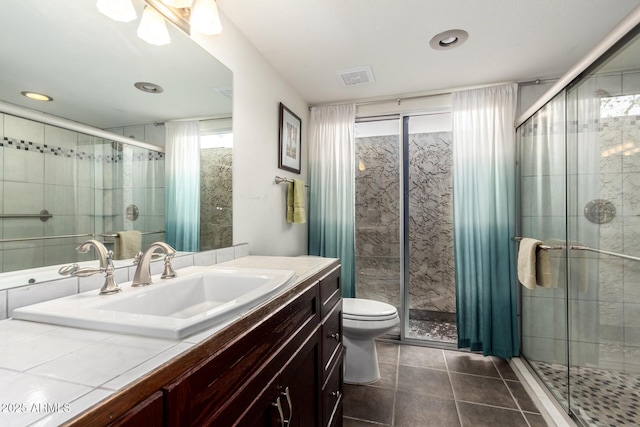 full bath with vanity, toilet, a shower stall, and tile patterned flooring