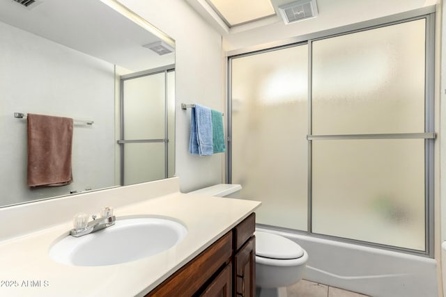 bathroom with vanity, toilet, visible vents, and enclosed tub / shower combo