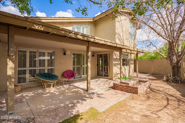 back of property featuring stucco siding, a patio, and fence