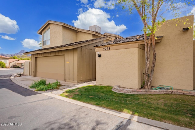 view of home's exterior featuring an attached garage, a yard, and stucco siding