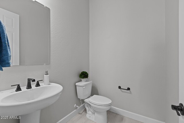 20209 W San Miguel Ave, Litchfield Park, AZ 85340 - bathroom with toilet, a sink, and baseboards