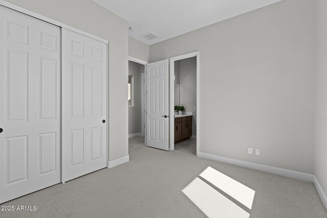 20209 W San Miguel Ave, Litchfield Park, AZ 85340 - unfurnished bedroom with light colored carpet, baseboards, a closet, and ensuite bathroom