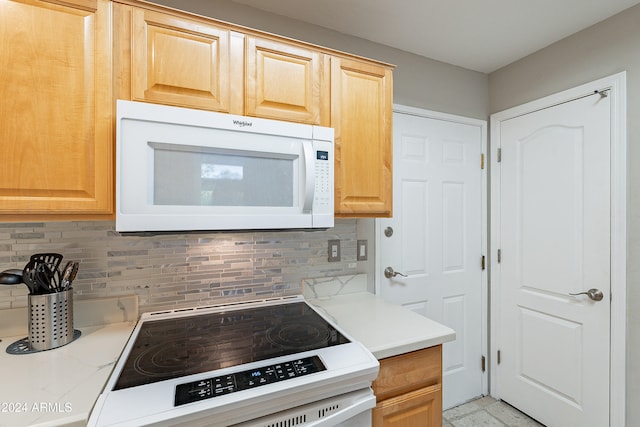 kitchen with range, backsplash, and light brown cabinets