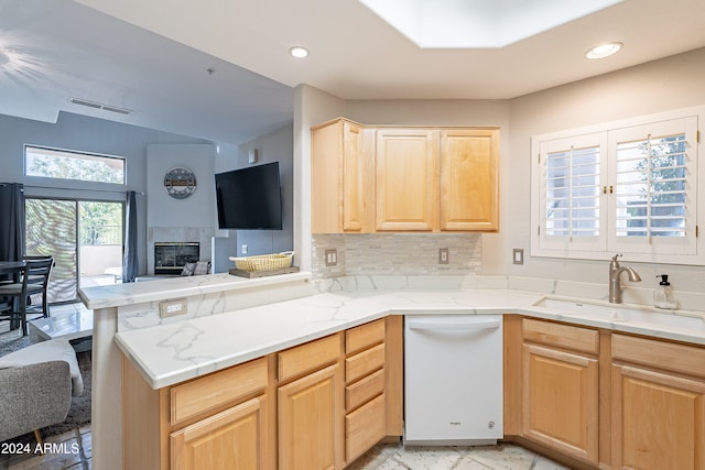 kitchen with dishwasher, light brown cabinets, sink, backsplash, and kitchen peninsula