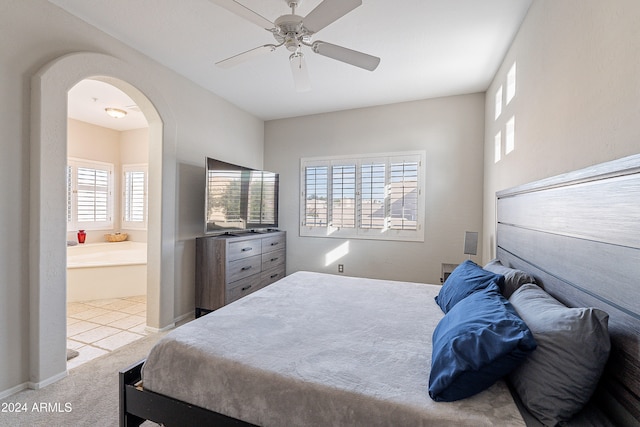 carpeted bedroom featuring ensuite bath and ceiling fan