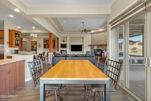 dining room featuring a fireplace and ceiling fan