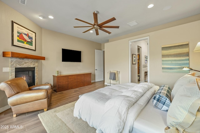 bedroom with a fireplace and ceiling fan