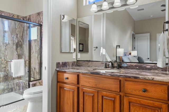 bathroom featuring walk in shower, vanity, and toilet