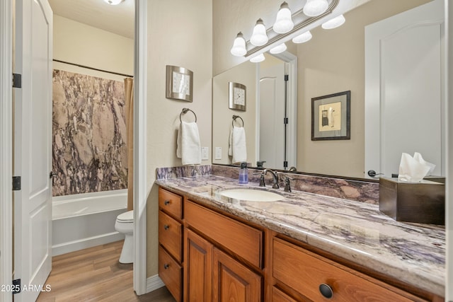 full bathroom with shower / bathtub combination with curtain, hardwood / wood-style floors, vanity, and toilet