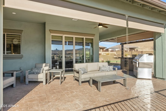 view of patio featuring an outdoor kitchen, ceiling fan, area for grilling, and an outdoor hangout area