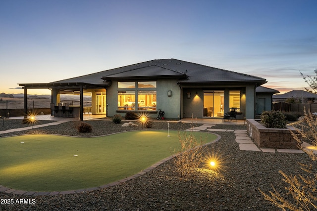 back house at dusk with a patio