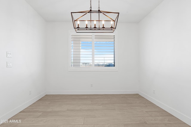 2083 W Lincoln Ct, San Tan Valley, AZ 85144 - spare room with a chandelier, light wood-style floors, and baseboards