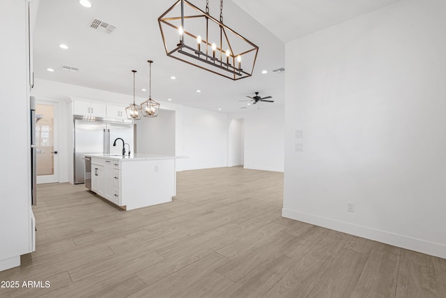 2083 W Lincoln Ct, San Tan Valley, AZ 85144 - unfurnished living room featuring light wood-style floors, a ceiling fan, recessed lighting, a chandelier, and a sink