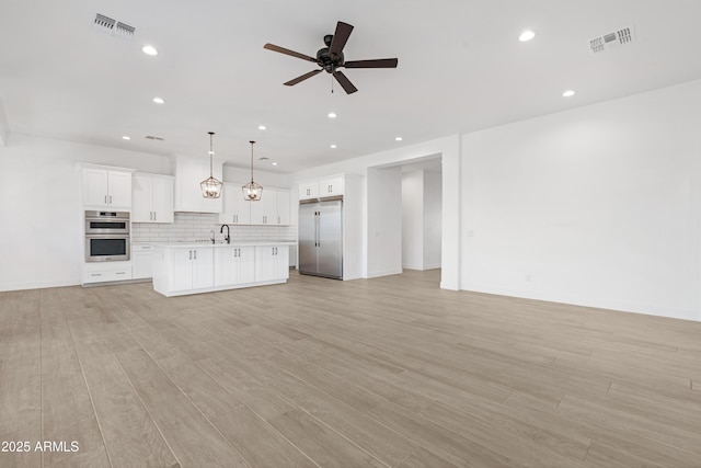 2083 W Lincoln Ct, San Tan Valley, AZ 85144 - unfurnished living room featuring ceiling fan, recessed lighting, light wood finished floors, and baseboards