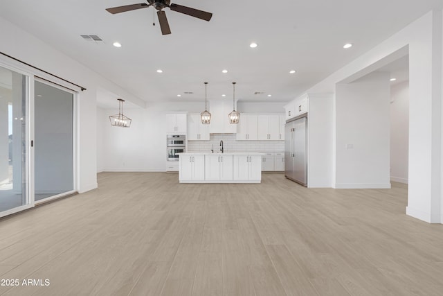 2083 W Lincoln Ct, San Tan Valley, AZ 85144 - unfurnished living room featuring a ceiling fan, baseboards, recessed lighting, a sink, and light wood finished floors