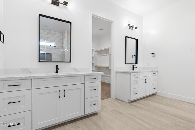 2083 W Lincoln Ct, San Tan Valley, AZ 85144 - bathroom featuring two vanities, wood finished floors, and baseboards