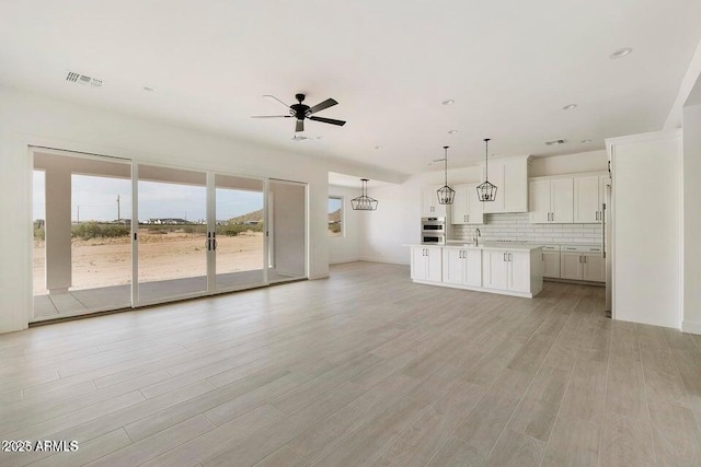 2083 W Lincoln Ct, San Tan Valley, AZ 85144 - unfurnished living room featuring a ceiling fan, light wood finished floors, a sink, and recessed lighting