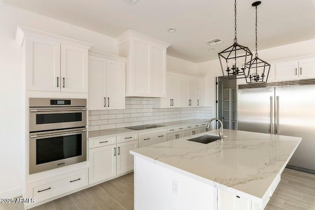 2083 W Lincoln Ct, San Tan Valley, AZ 85144 - kitchen with a sink, appliances with stainless steel finishes, white cabinetry, a chandelier, and decorative backsplash