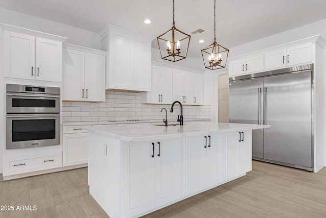 2083 W Lincoln Ct, San Tan Valley, AZ 85144 - kitchen featuring appliances with stainless steel finishes, a chandelier, recessed lighting, white cabinetry, and tasteful backsplash