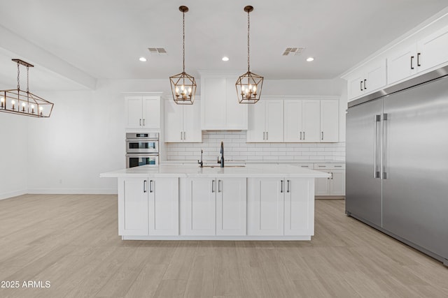 2083 W Lincoln Ct, San Tan Valley, AZ 85144 - kitchen featuring appliances with stainless steel finishes, a chandelier, a sink, light countertops, and backsplash