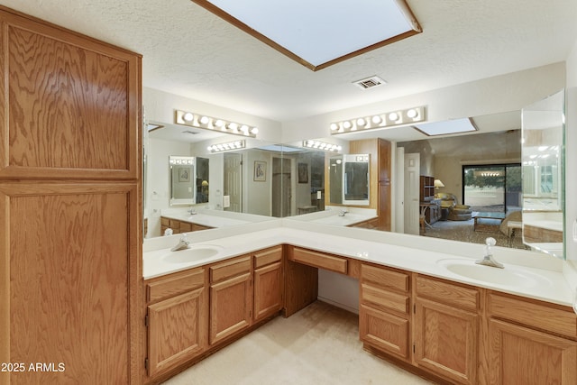 bathroom with visible vents, a sink, and double vanity