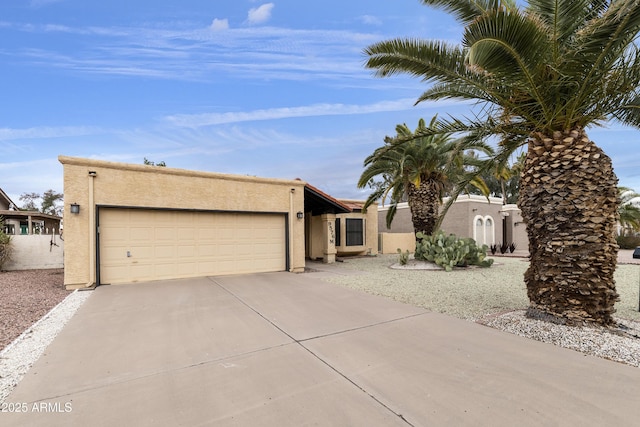 view of front facade featuring an attached garage, concrete driveway, and stucco siding