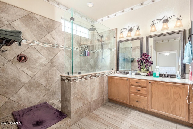 full bathroom featuring a sink, a walk in shower, and double vanity