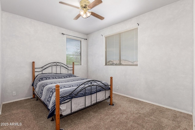 carpeted bedroom featuring baseboards and a ceiling fan