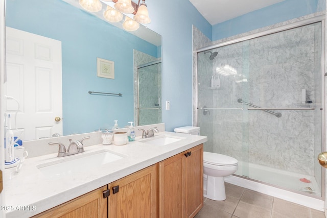 bathroom with a sink, toilet, a shower stall, and a chandelier