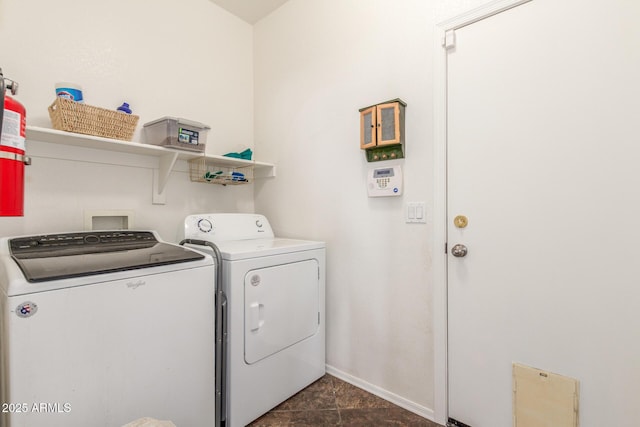 washroom with baseboards, washing machine and dryer, and laundry area