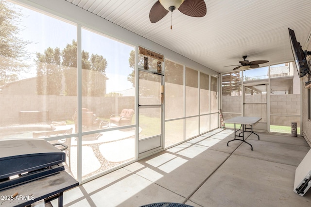 unfurnished sunroom featuring a ceiling fan