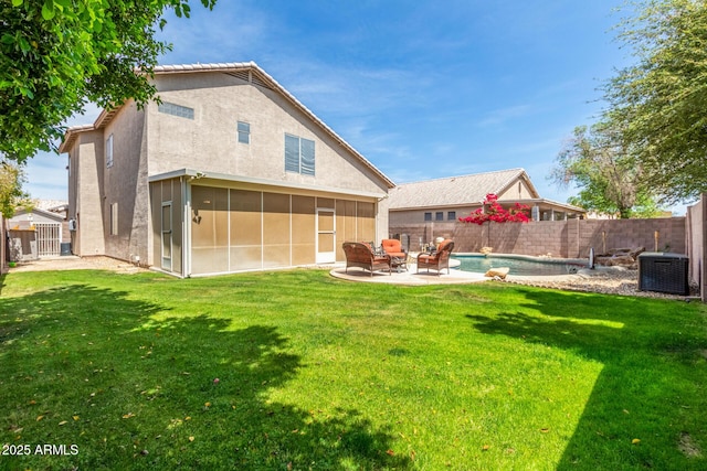 back of property with a sunroom, a yard, a patio area, and a fenced backyard