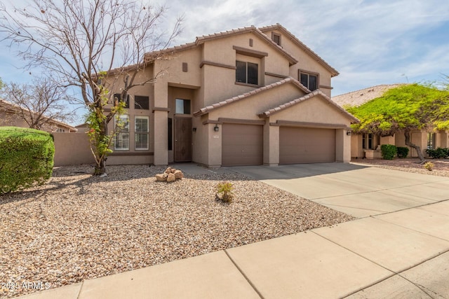view of front of home featuring stucco siding, fence, a tile roof, an attached garage, and concrete driveway