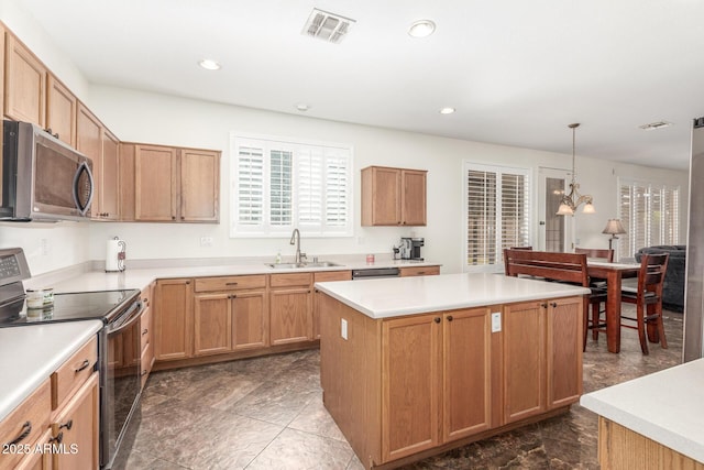 kitchen featuring visible vents, a center island, stainless steel microwave, a sink, and range with electric stovetop