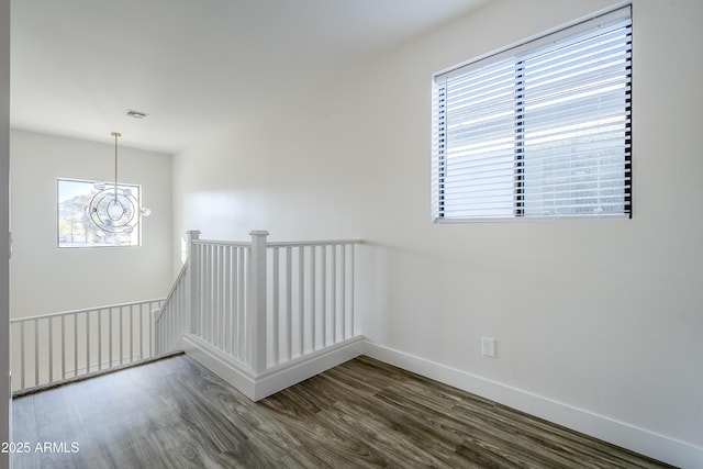 empty room featuring hardwood / wood-style floors and an inviting chandelier