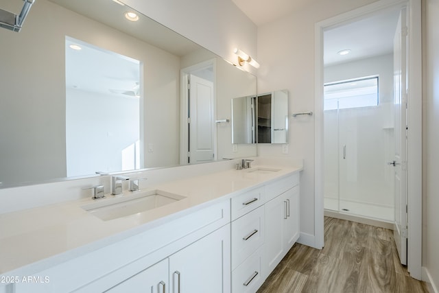 bathroom with vanity, hardwood / wood-style floors, and a shower with door