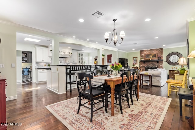 4710 N 33rd Pl, Phoenix, AZ 85018 - dining room featuring a chandelier, dark wood finished floors, crown molding, a brick fireplace, and recessed lighting