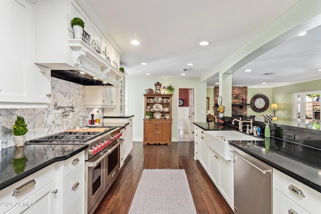 4710 N 33rd Pl, Phoenix, AZ 85018 - kitchen featuring stainless steel appliances, dark wood-style floors, white cabinetry, tasteful backsplash, and recessed lighting