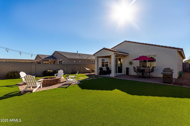 back of house featuring a yard, a pergola, a patio area, and a fire pit