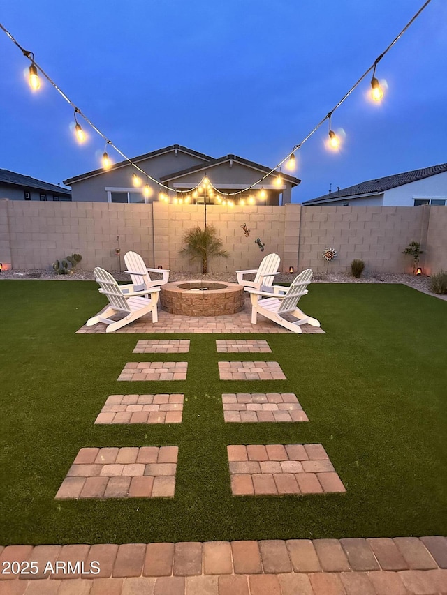 yard at dusk featuring a fire pit and a patio